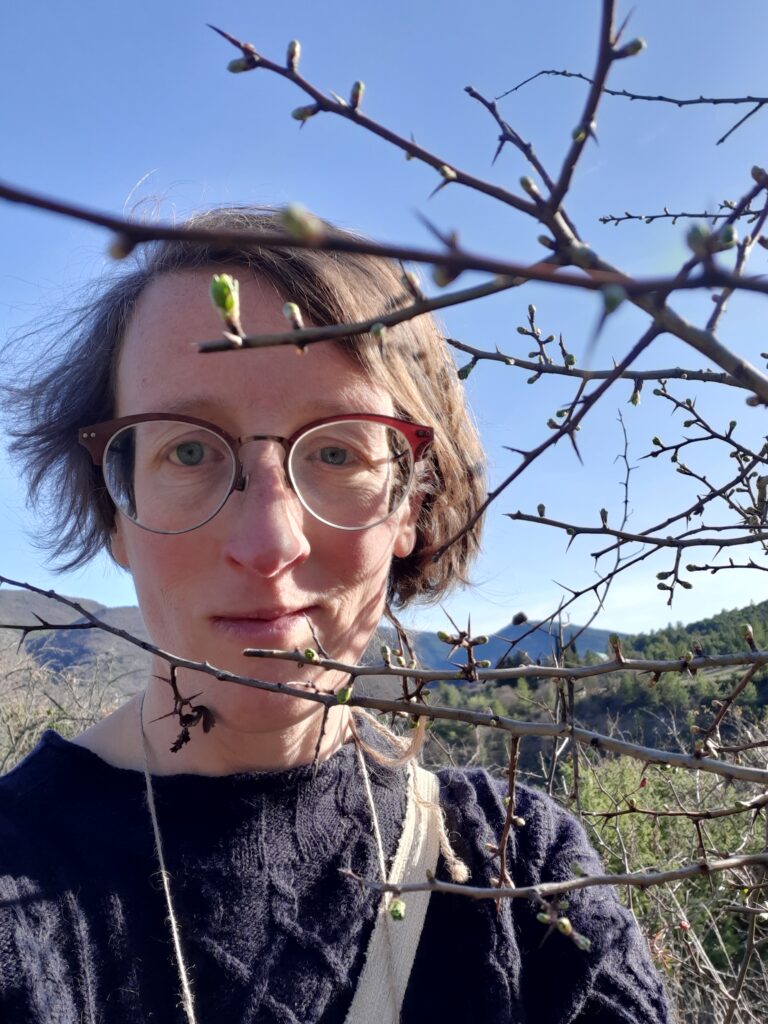 Violaine Peeters derrière un rameau et ses bourgeons